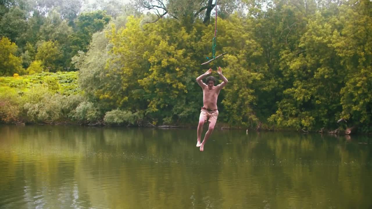 Stock Video Man Jumps Into A Lake By Swinging With A Rop Animated Wallpaper - Free Download