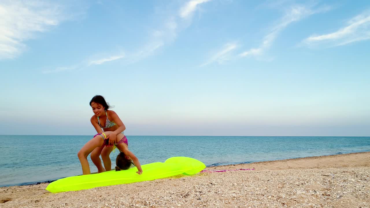 Stock Video Little Sisters Practice Gymnastics On The Seashore Animated Wallpaper - Free Download