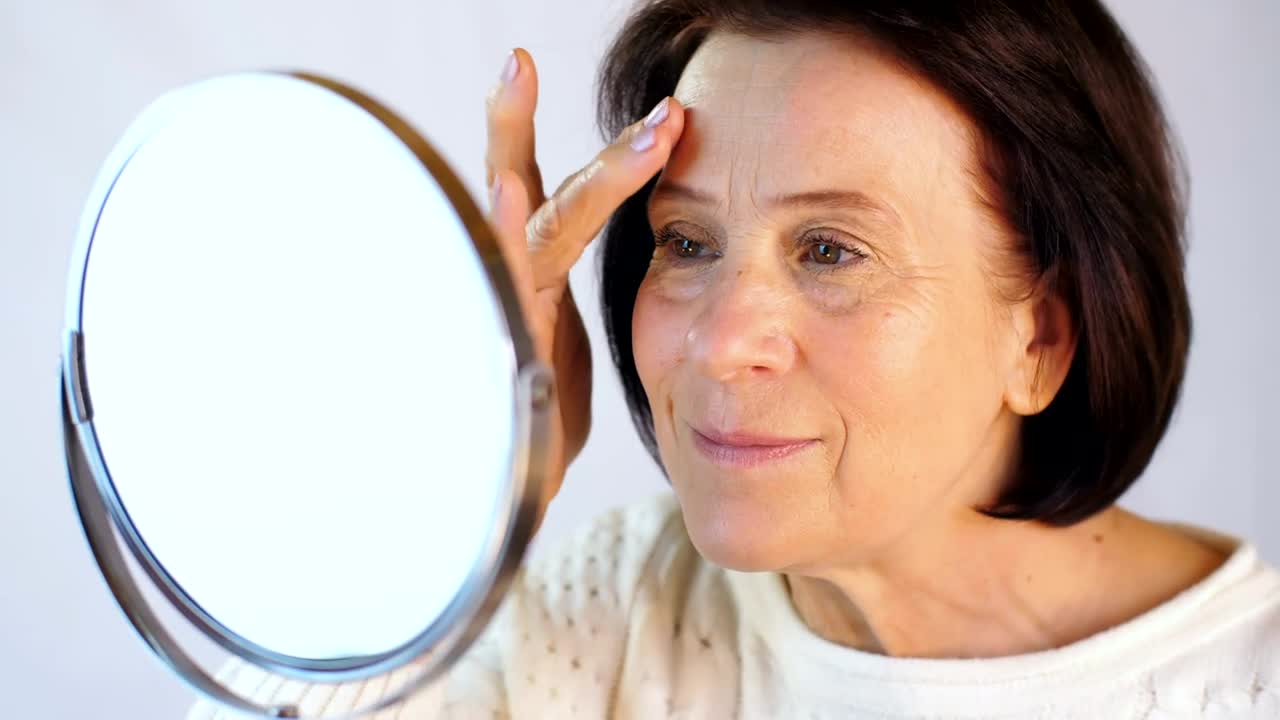 Stock Video Elderly Woman Touching Her Face In A Small Mirror Live Wallpaper For PC - Free Download