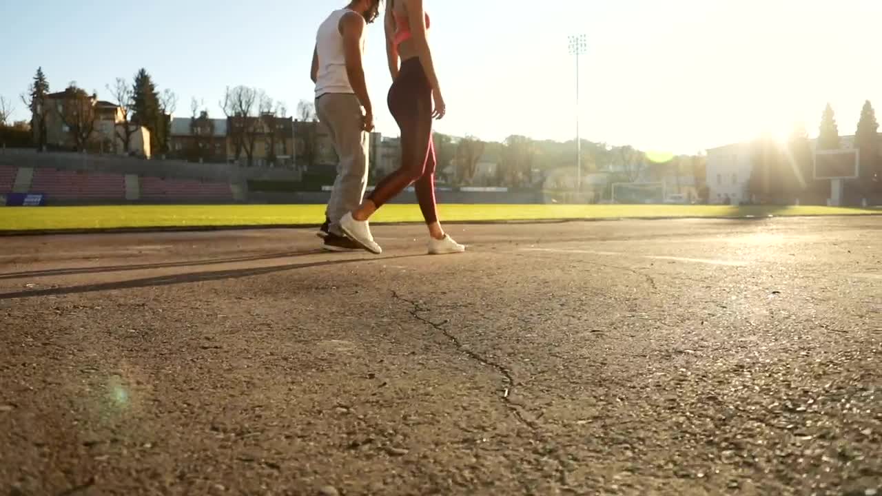 Stock Video Motivated Couple Lunge At Start Of Race On Outdoor Track Live Wallpaper - Free Download