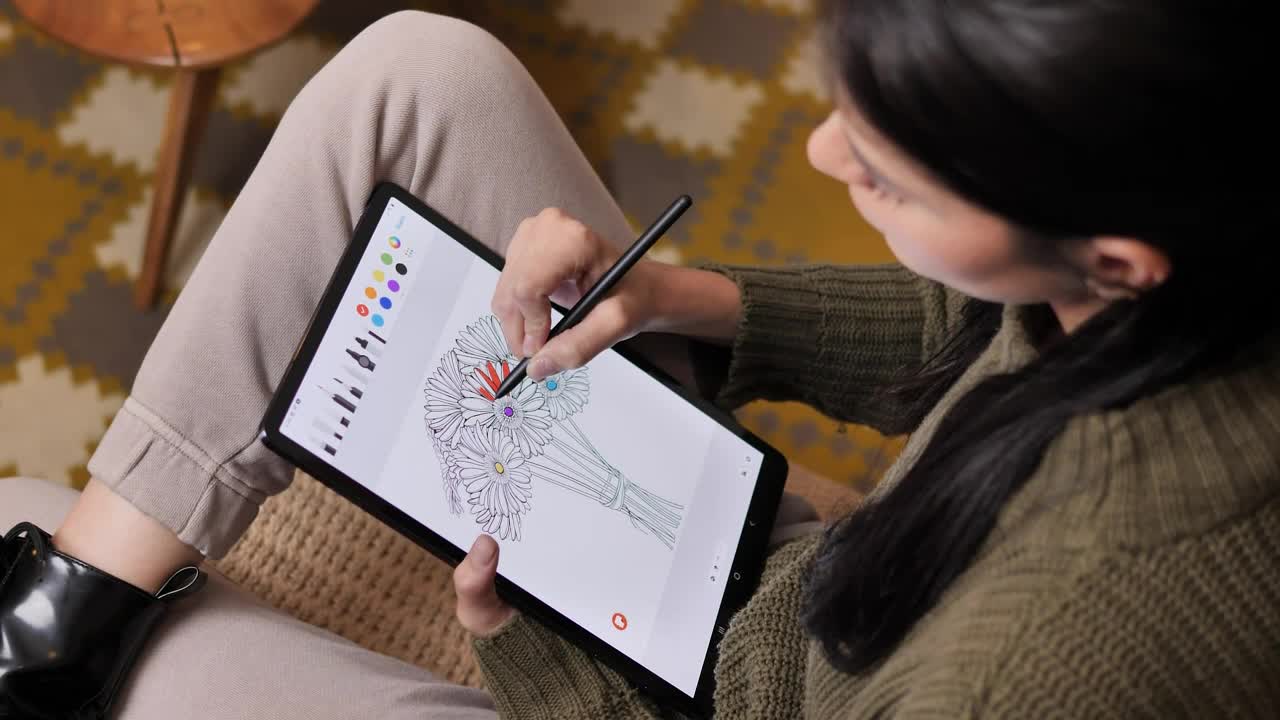 Stock Video Girl On A Sofa Coloring Flowers On A Tablet Live Wallpaper For PC - Free Download