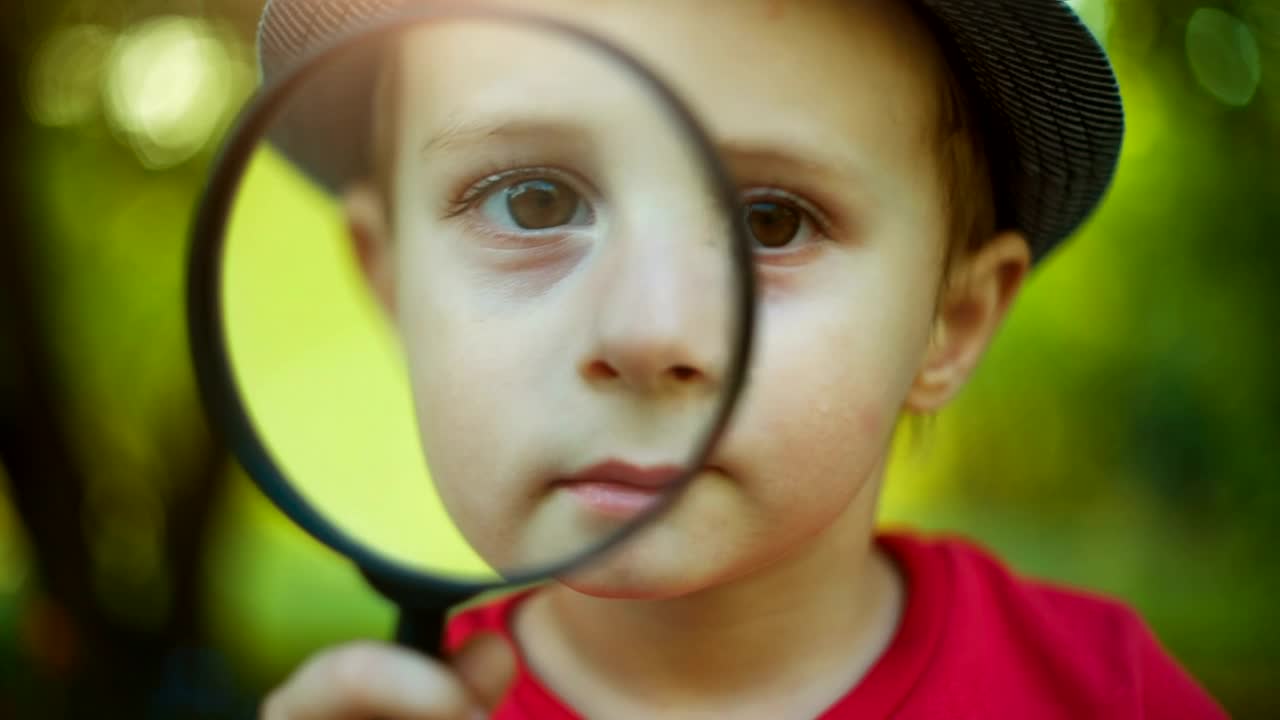 Stock Video Little Boy Looking Through A Magnifying Glass Animated Wallpaper - Free Download
