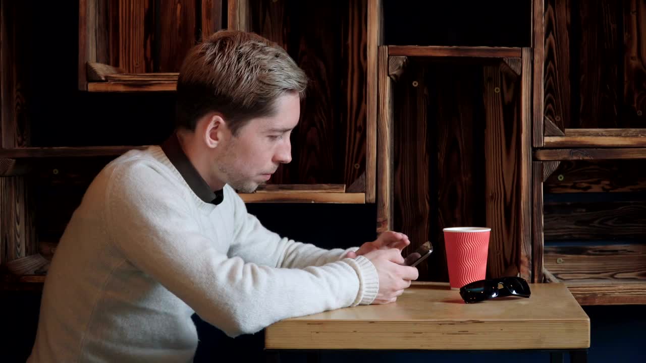 Stock Video Man Scrolling Through His Phone In A Caf Animated Wallpaper - Free Download