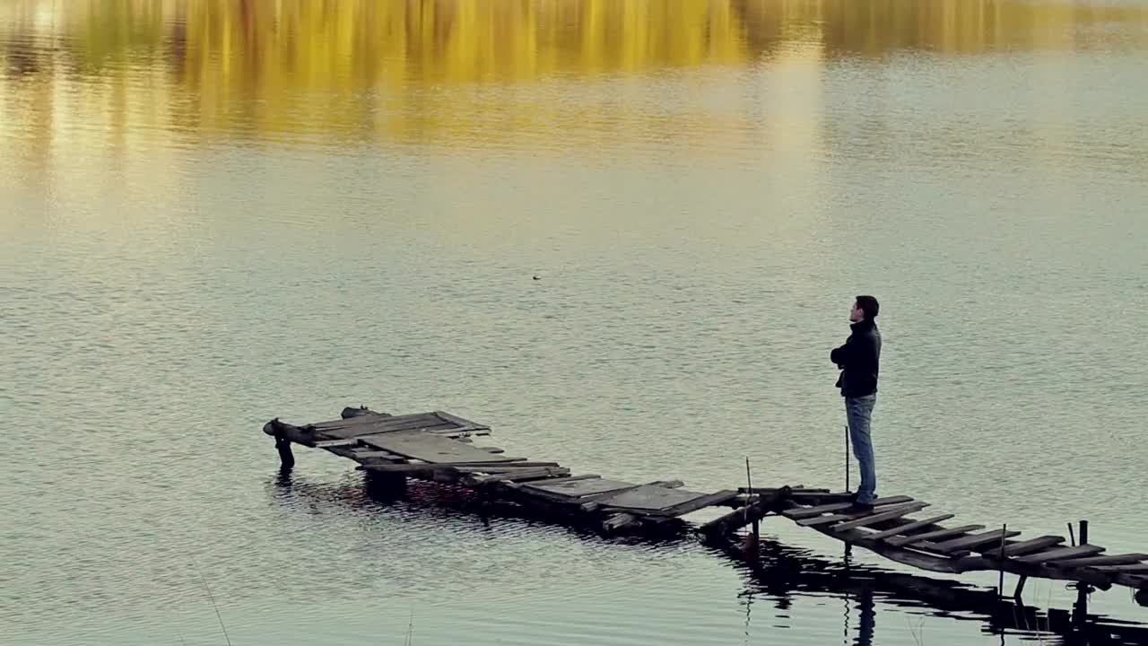 Stock Video Man Appreciating A Lake On A Worn And Broken Pier Animated Wallpaper - Free Download