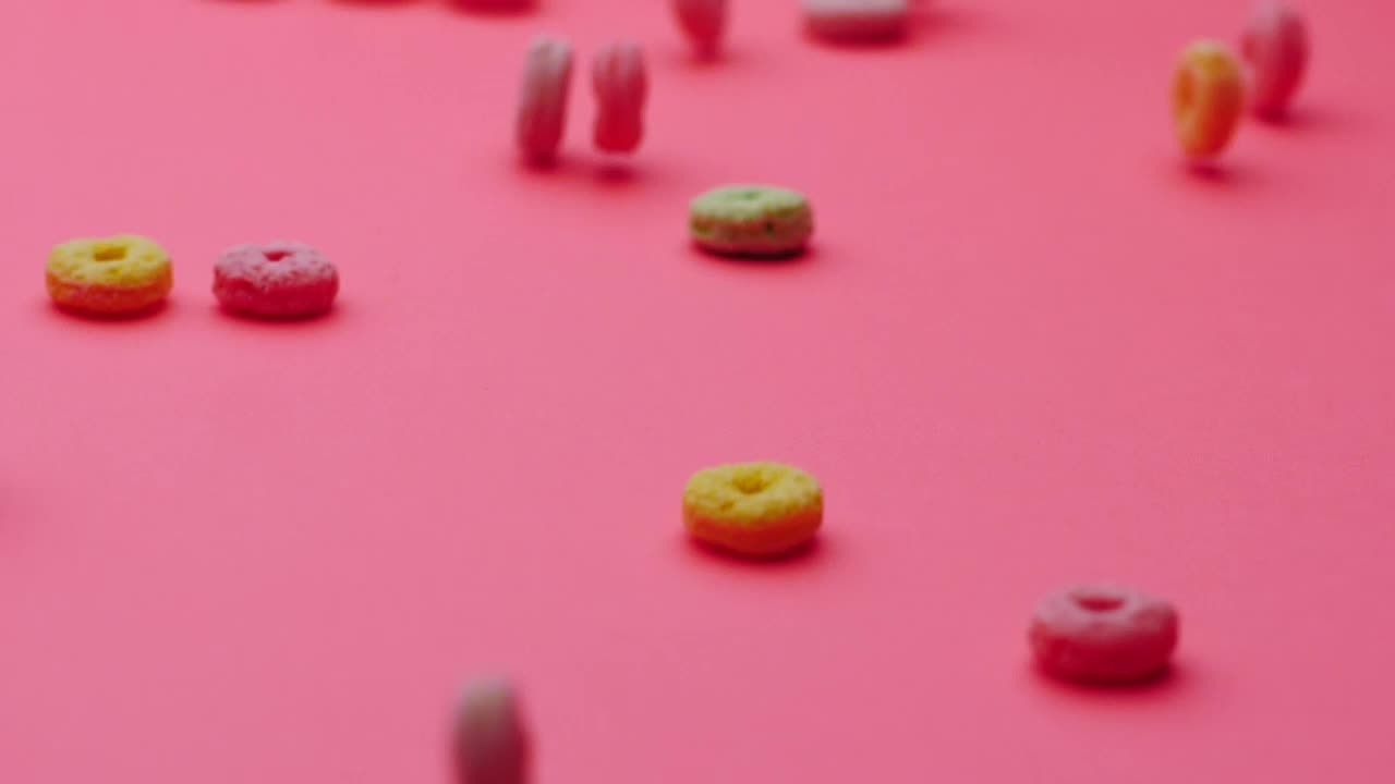 Stock Video Hoop Cereal Gliding On A Pink Surface Animated Wallpaper - Free Download