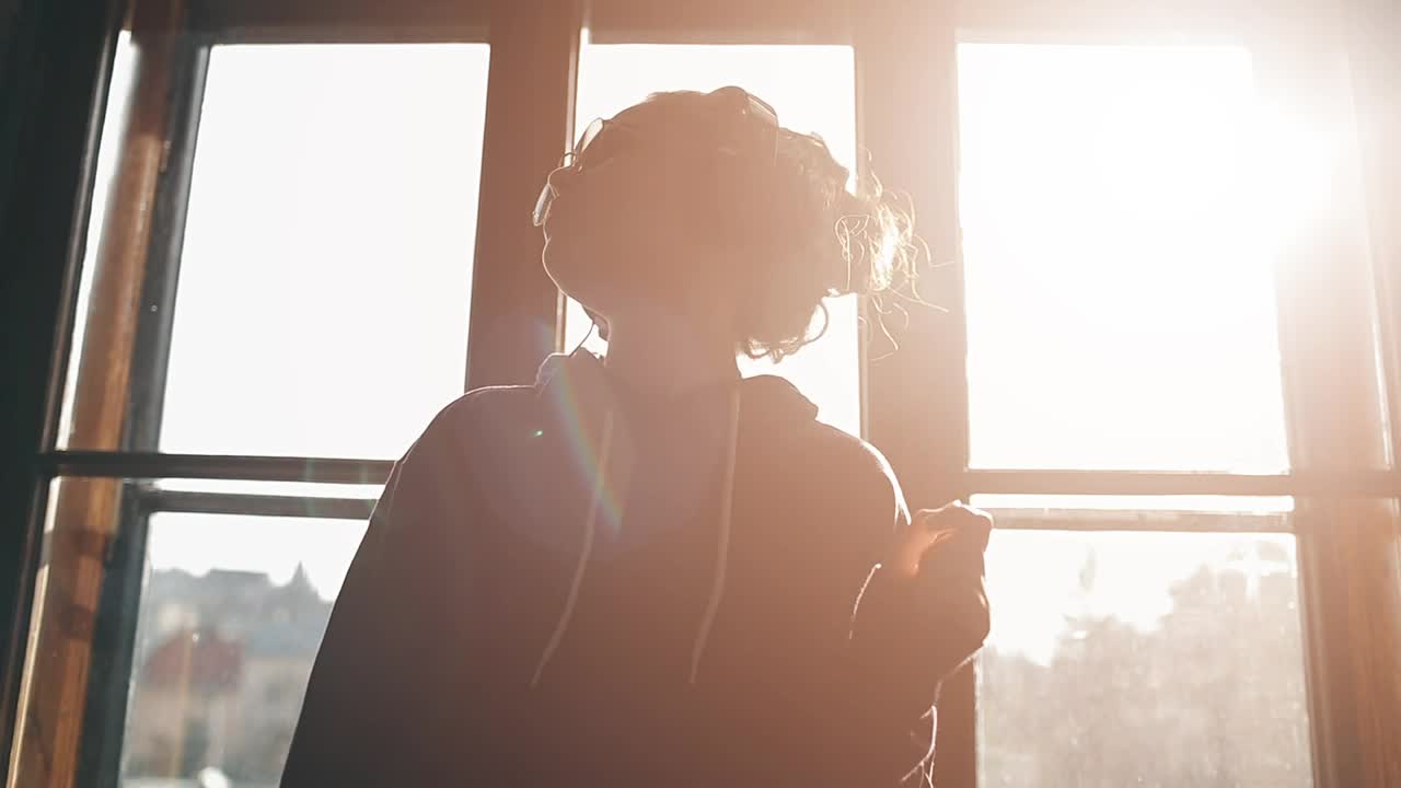 Stock Video Girl Enjoying Music Dances By Sunlit Window Live Wallpaper For PC - Free Download