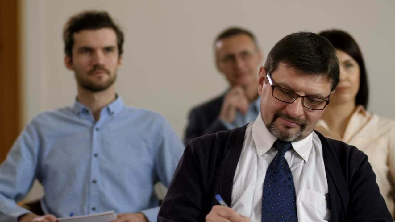 Free Video Stock taking notes while listening to a speaker Live Wallpaper - Free Download