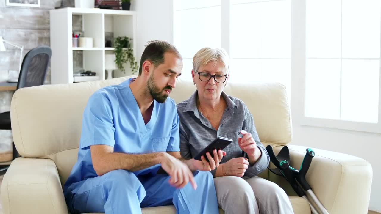 Stock Video Nurse Helps Woman Use App On Mobile Phone Live Wallpaper - Free Download