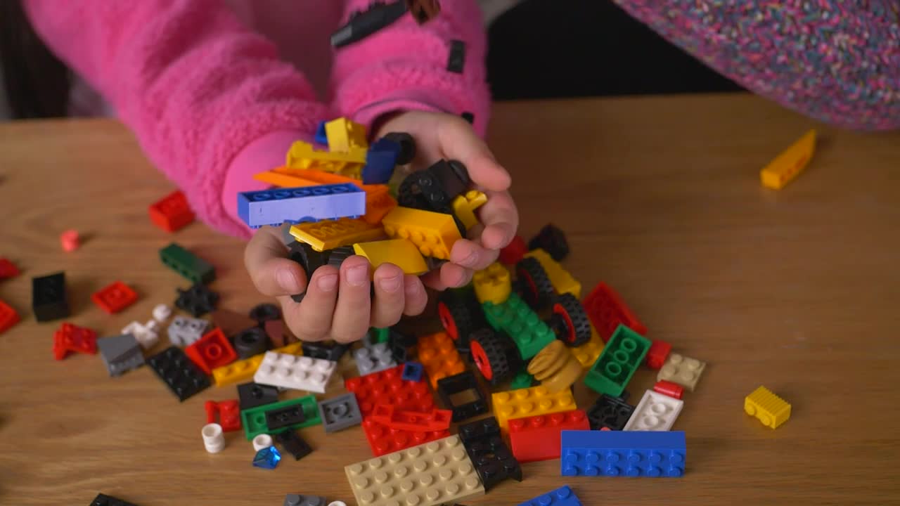 Stock Video Many Lego Pieces Falling Into The Hands Of A Gir Animated Wallpaper - Free Download