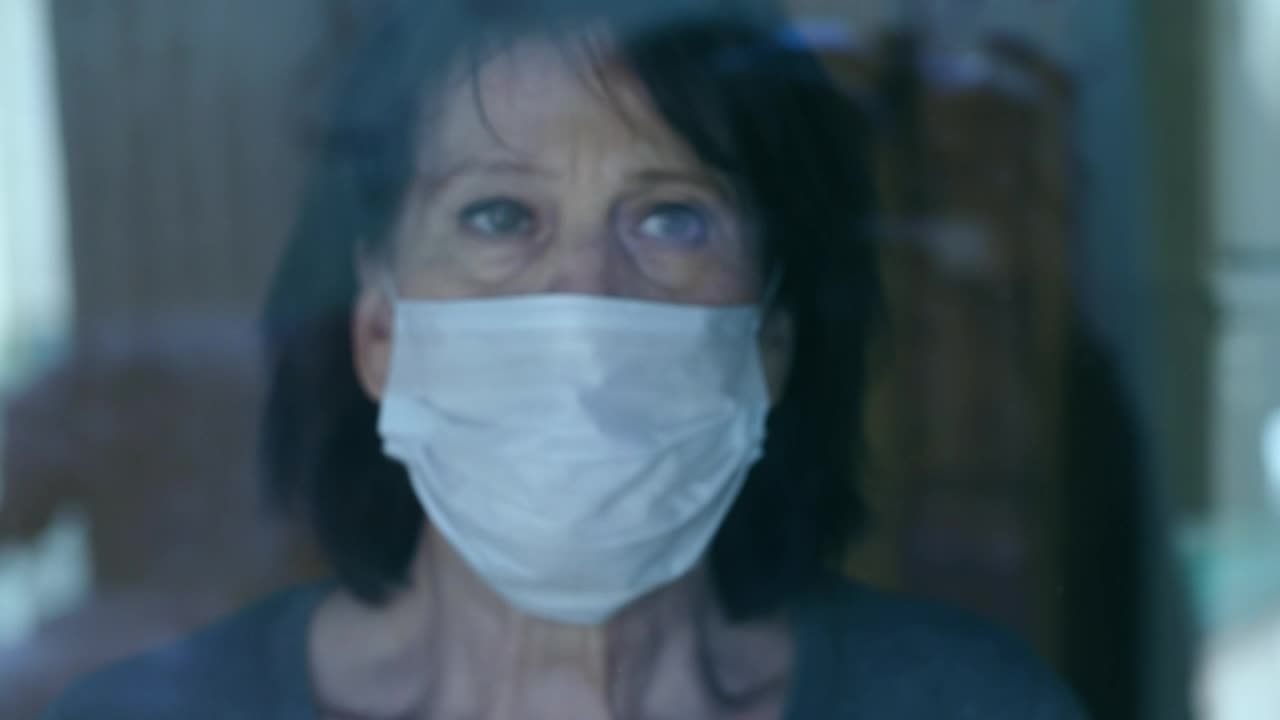 Stock Video Old Woman Looks Out The Window Wearing Mask Live Wallpaper - Free Download