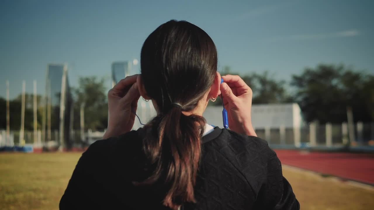 Stock Footage Woman Adjusting Her Headphones To Start Running Live Wallpaper - Free Download