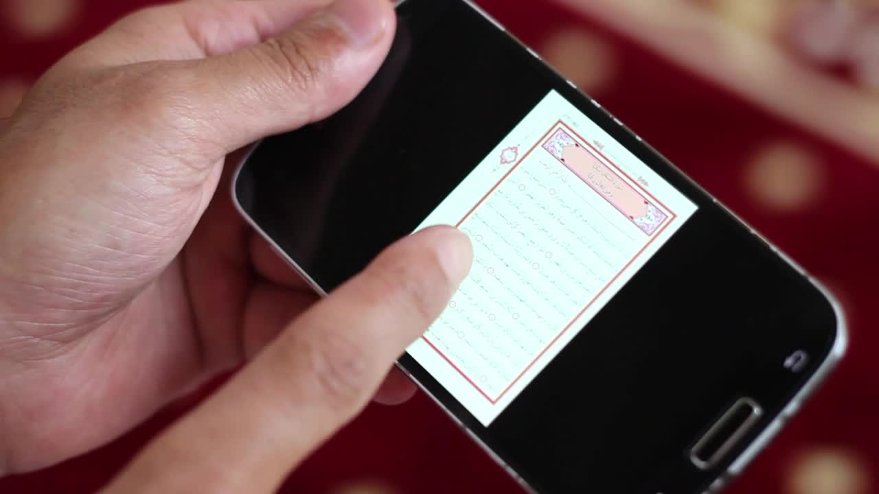 Stock Video Hands Hold A Cell To Reading The Quran In Digital Animated Wallpaper - Free Download