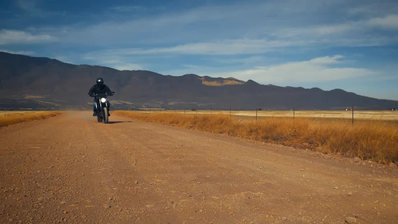 Stock Video Motorcyclist Crossing A Dirt Road In A Desert Live Wallpaper - Free Download
