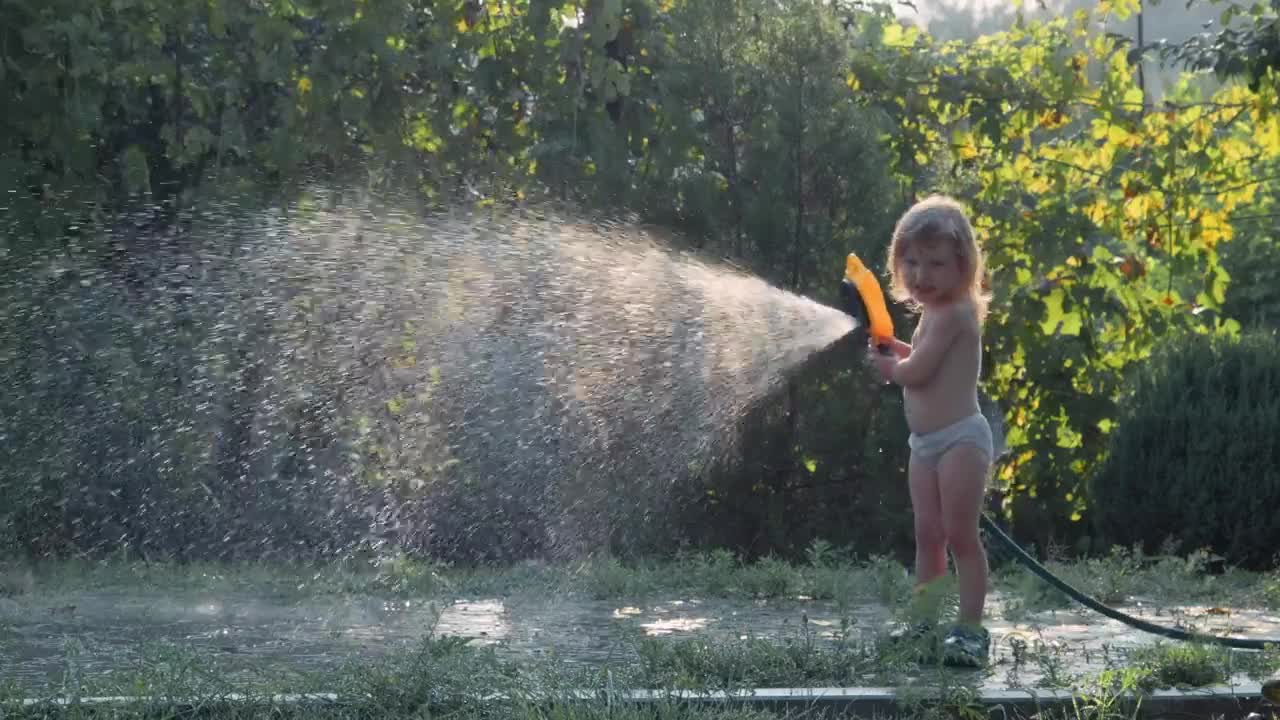 Stock Video Little Girl Playing With The Water Hose Animated Wallpaper - Free Download