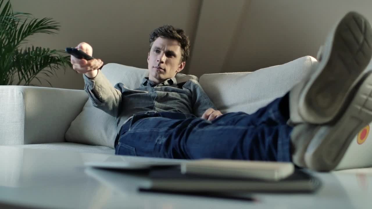 Stock Video Man Changing The Tv Channels From The Couch Animated Wallpaper - Free Download