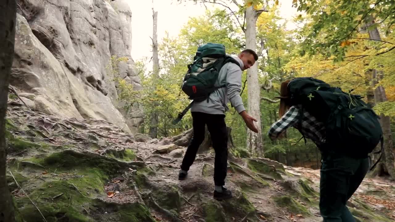 Stock Video Man Helping Woman Up Hill While Hiking Animated Wallpaper - Free Download