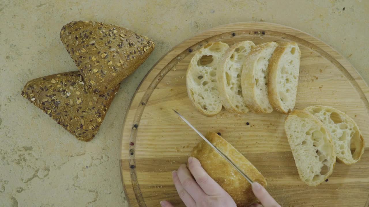 Free Video Stock top view of hands cutting fresh bread on wood board Live Wallpaper - Free Download