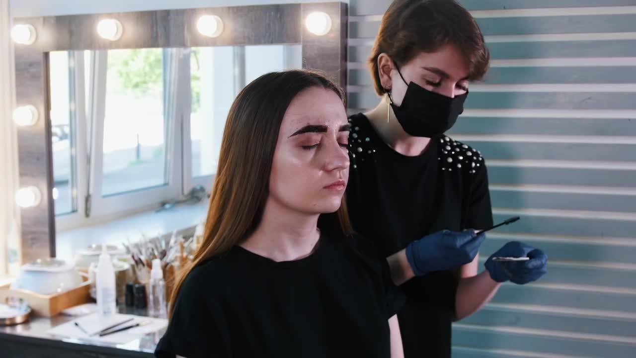 Stock Video Makeup Artist With Medical Mask Working On A Womans Eyebrows Animated Wallpaper - Free Download