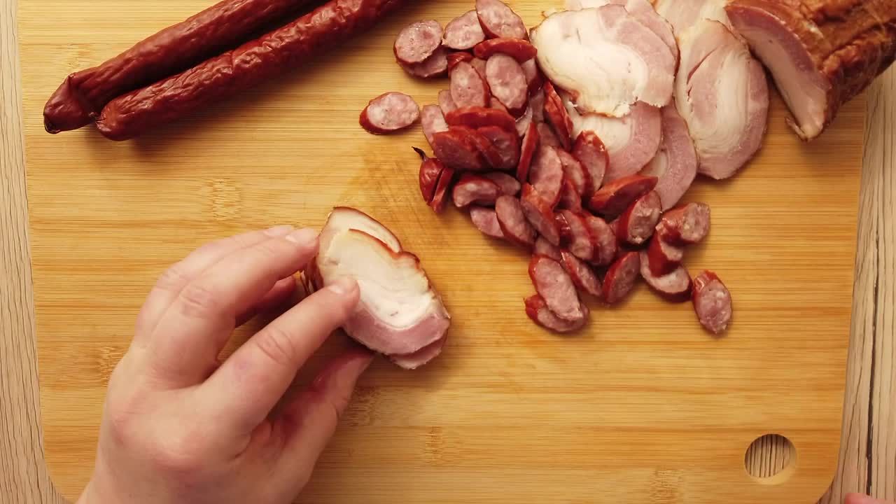 Stock Video Hands Of A Person Cutting Sausages On A Board Animated Wallpaper - Free Download