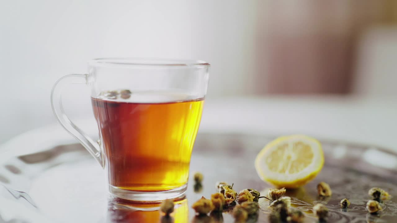 Stock Video Lemon Slice Dropped Into Tea In Clear Glass Animated Wallpaper - Free Download