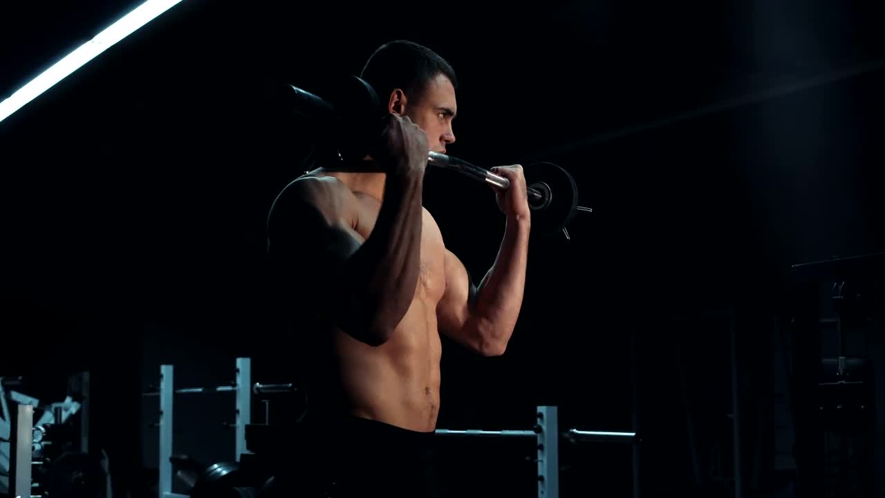 Stock Video Muscular Man Lifting A Barbell In A Dark Gym Live Wallpaper - Free Download