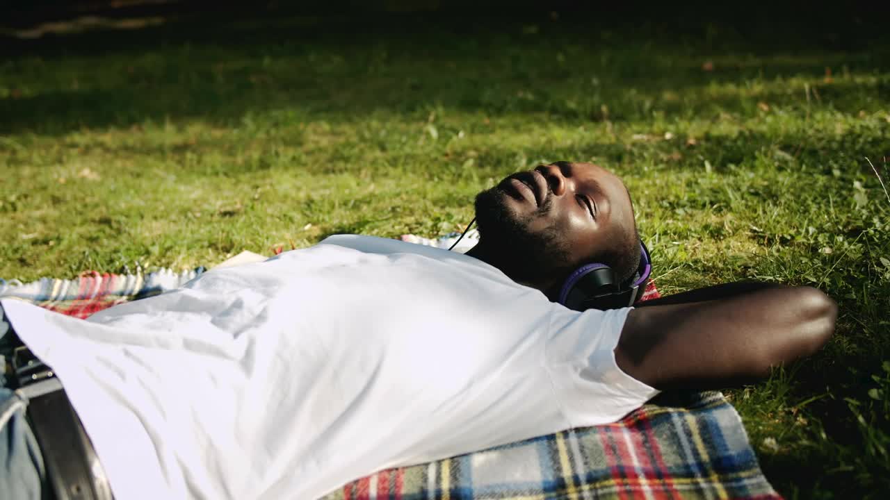 Free Stock Video Relaxed Man Enjoys Music While Lying On Grass Live Wallpaper - Free Download