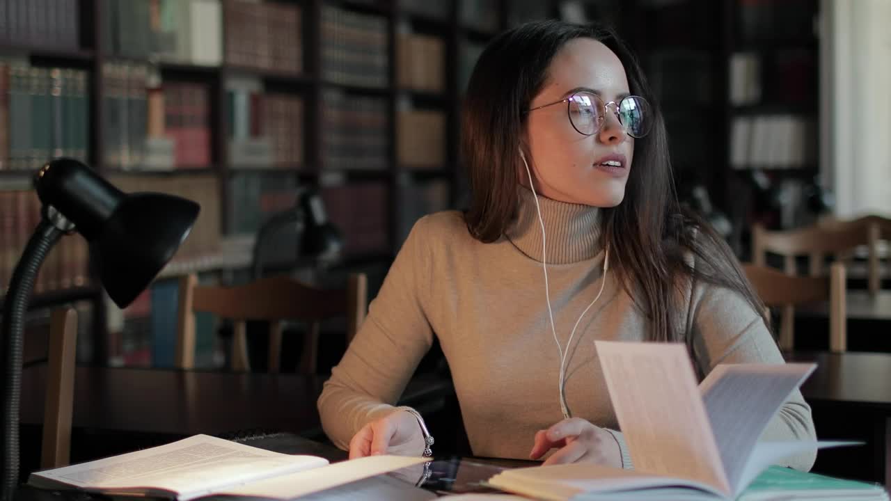 Stock Video Girl Rubs Head In Pain While Studying Late In Library Live Wallpaper For PC - Free Download