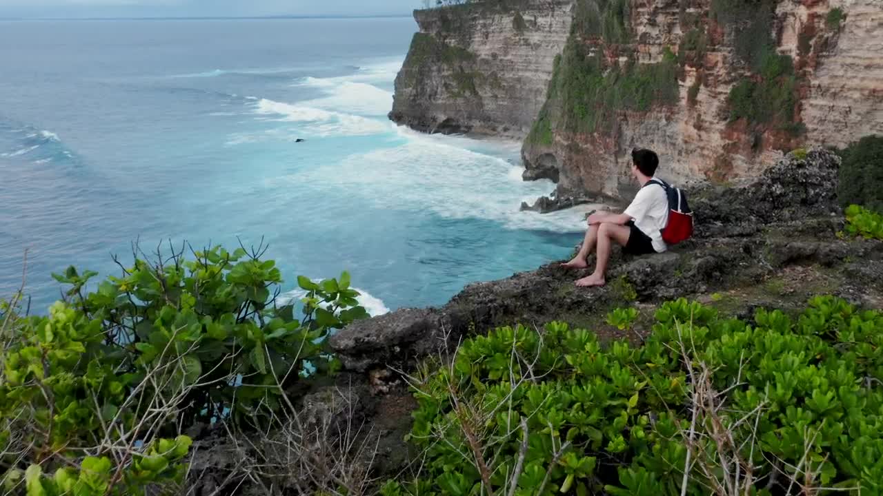 Stock Video Man Looks Over Cliff Edge To Sea On Bali Indonesi Animated Wallpaper - Free Download