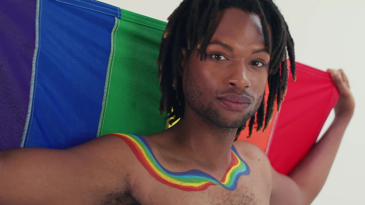 Stock Video Lgbtq Man Looking At The Camera With His Flag Animated Wallpaper - Free Download