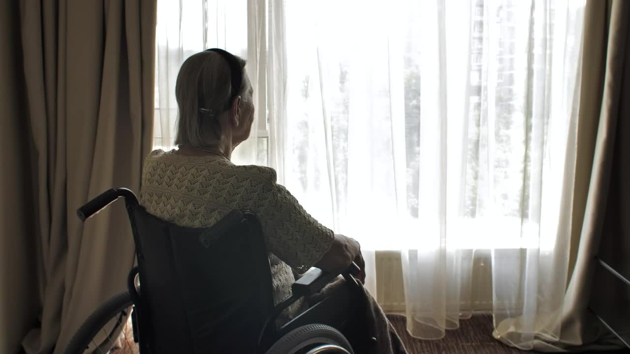 Stock Video Elderly Woman In Wheelchair Looking Out The Window Live Wallpaper For PC - Free Download