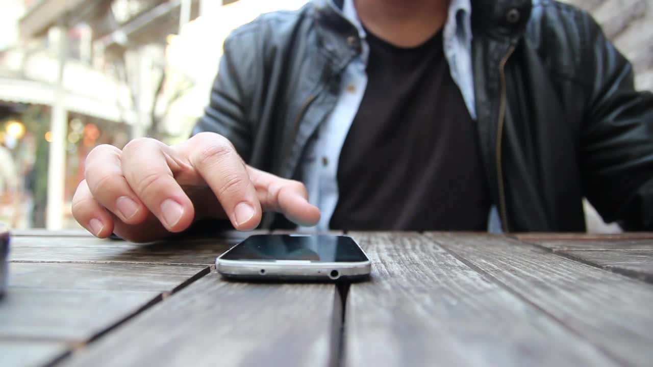 Stock Video Man Using A Smartphone On A Wooden Tabl Animated Wallpaper - Free Download