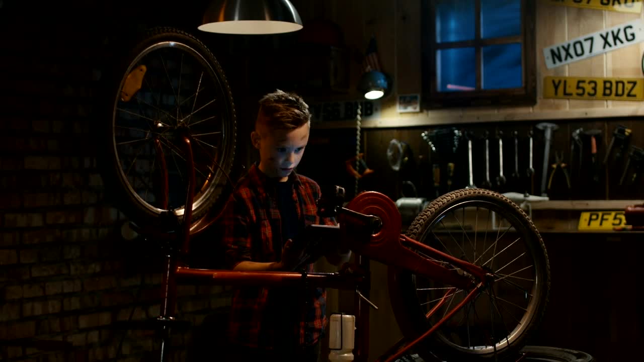 Free Video Stock teen boy watching tutorial to repair the bicycle Live Wallpaper - Free Download