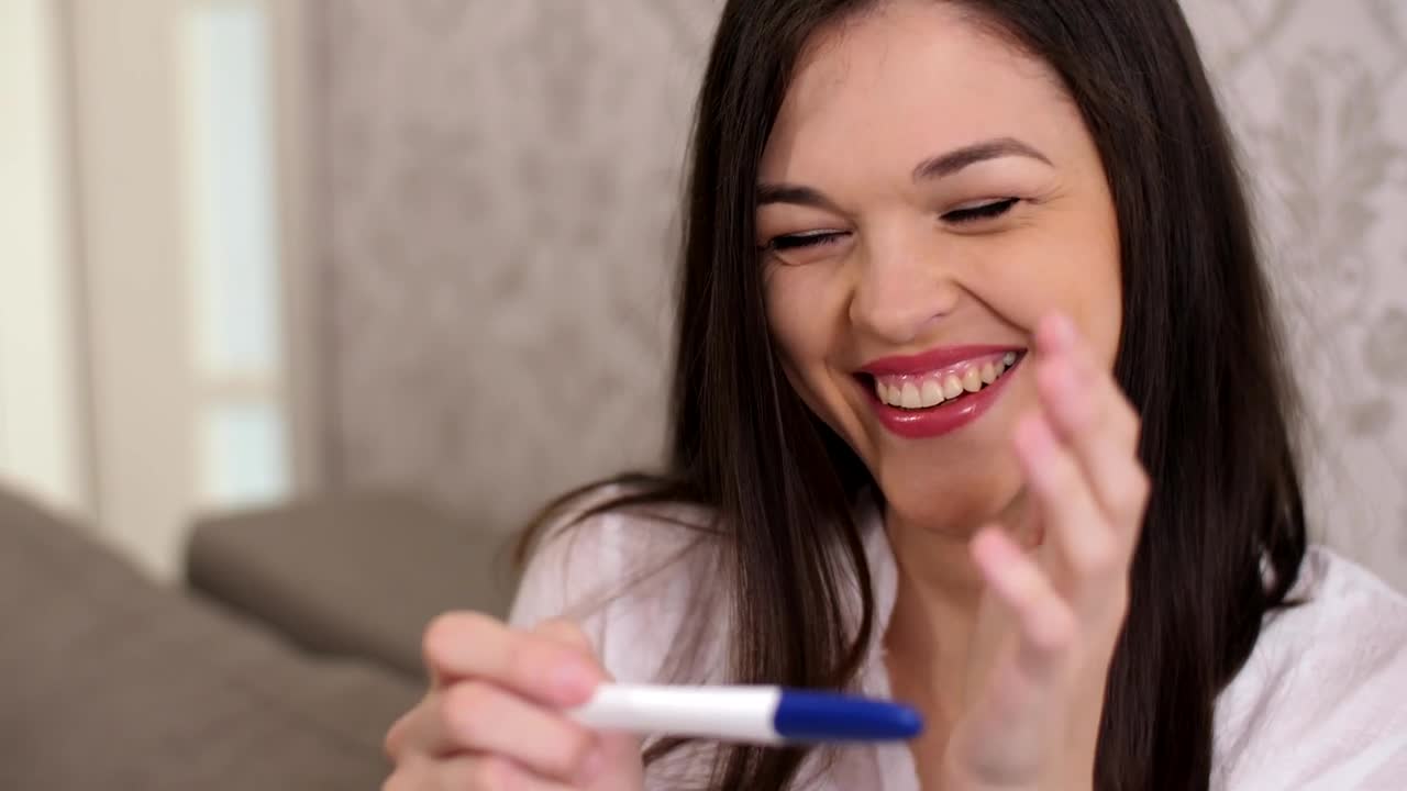 Stock Video Happy Woman Smiles When Checking That She Is Pregnant Animated Wallpaper - Free Download