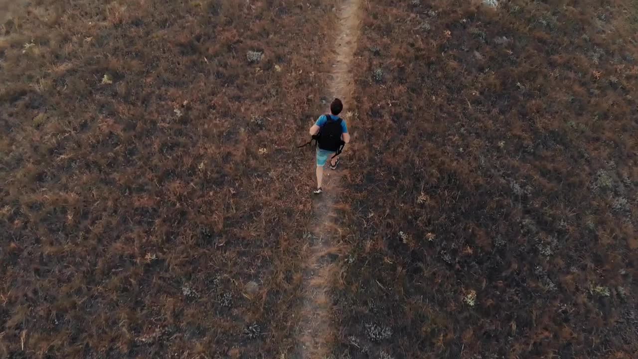 Stock Video Man Walking Down A Hill In An Aerial Sho Animated Wallpaper - Free Download