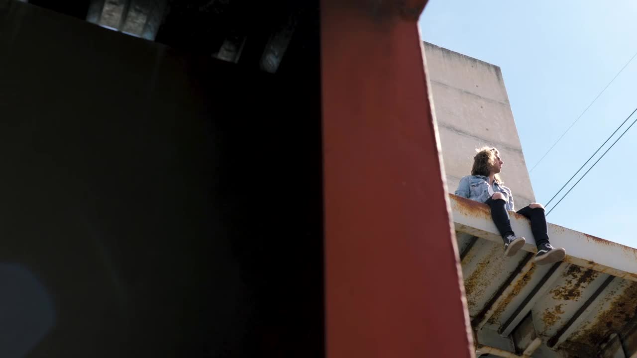Video Stock Person Sits On Awning Of Abandoned Building Live Wallpaper Free - Free Download