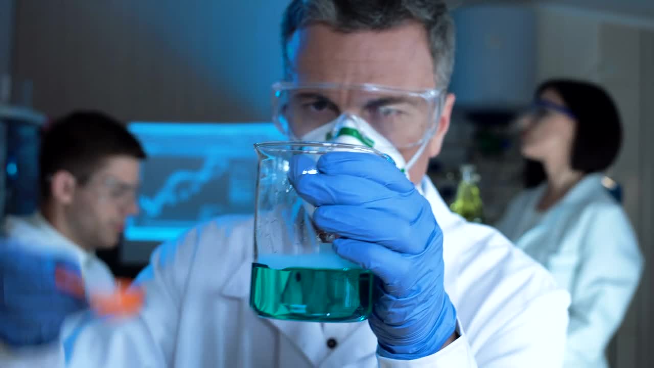 Stock Video Man Checking A Chemical Flask With Blue Liquid Animated Wallpaper - Free Download