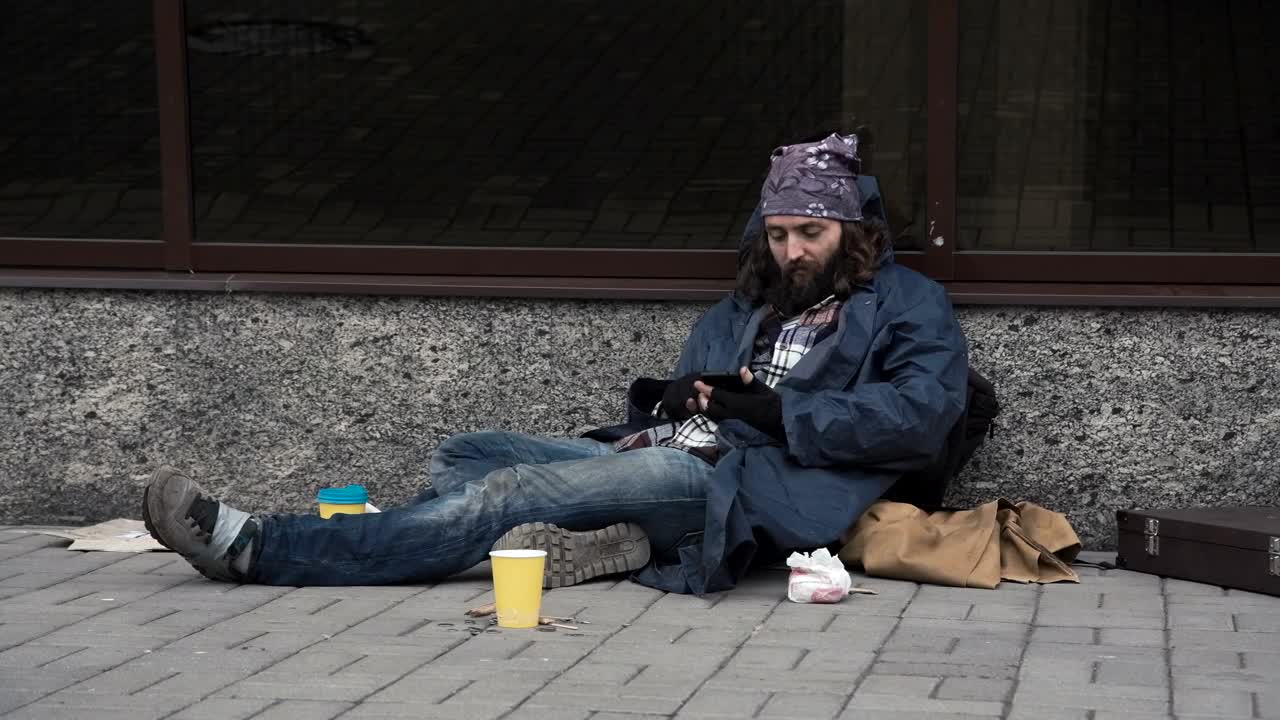 Stock Video Homeless Man Using Smartphone On The Street Animated Wallpaper - Free Download