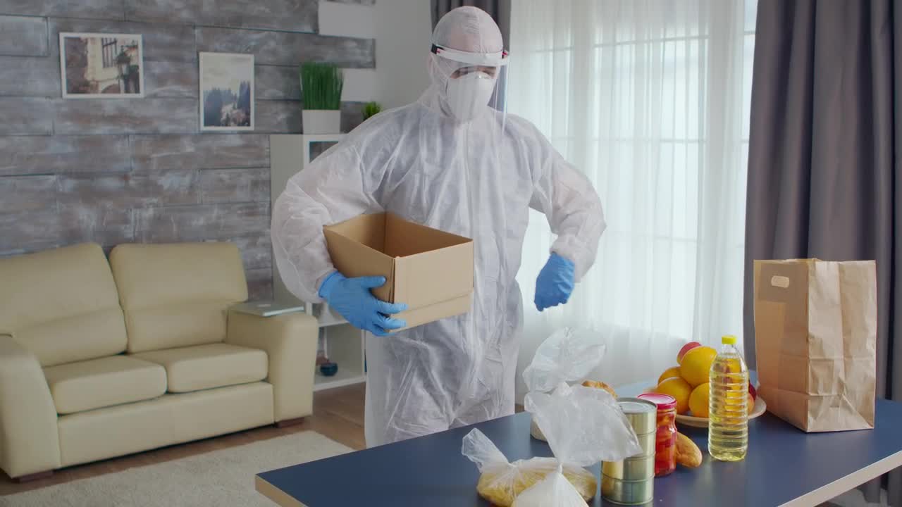 Stock Video Person In Coronavirus Quarantine Packs Food Into Box Live Wallpaper - Free Download