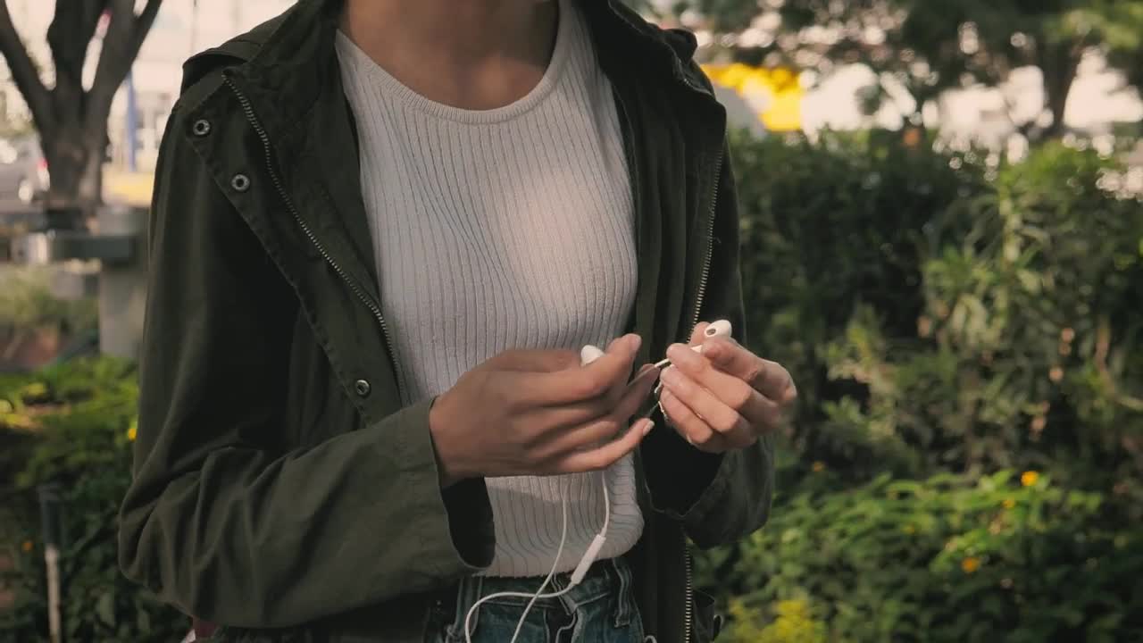Stock Footage Urban Woman Putting On Her Headphones While Walking Live Wallpaper - Free Download