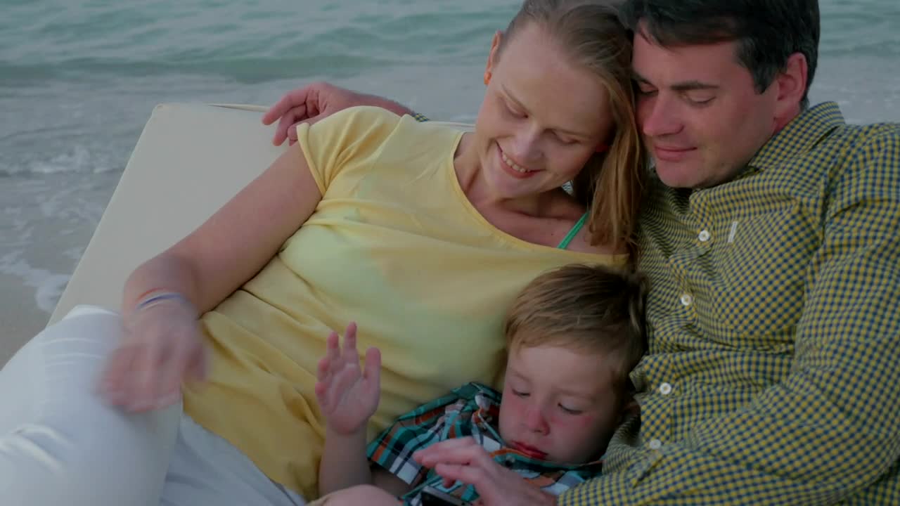 Stock Video Parents Laying With Their Tired Child Live Wallpaper - Free Download