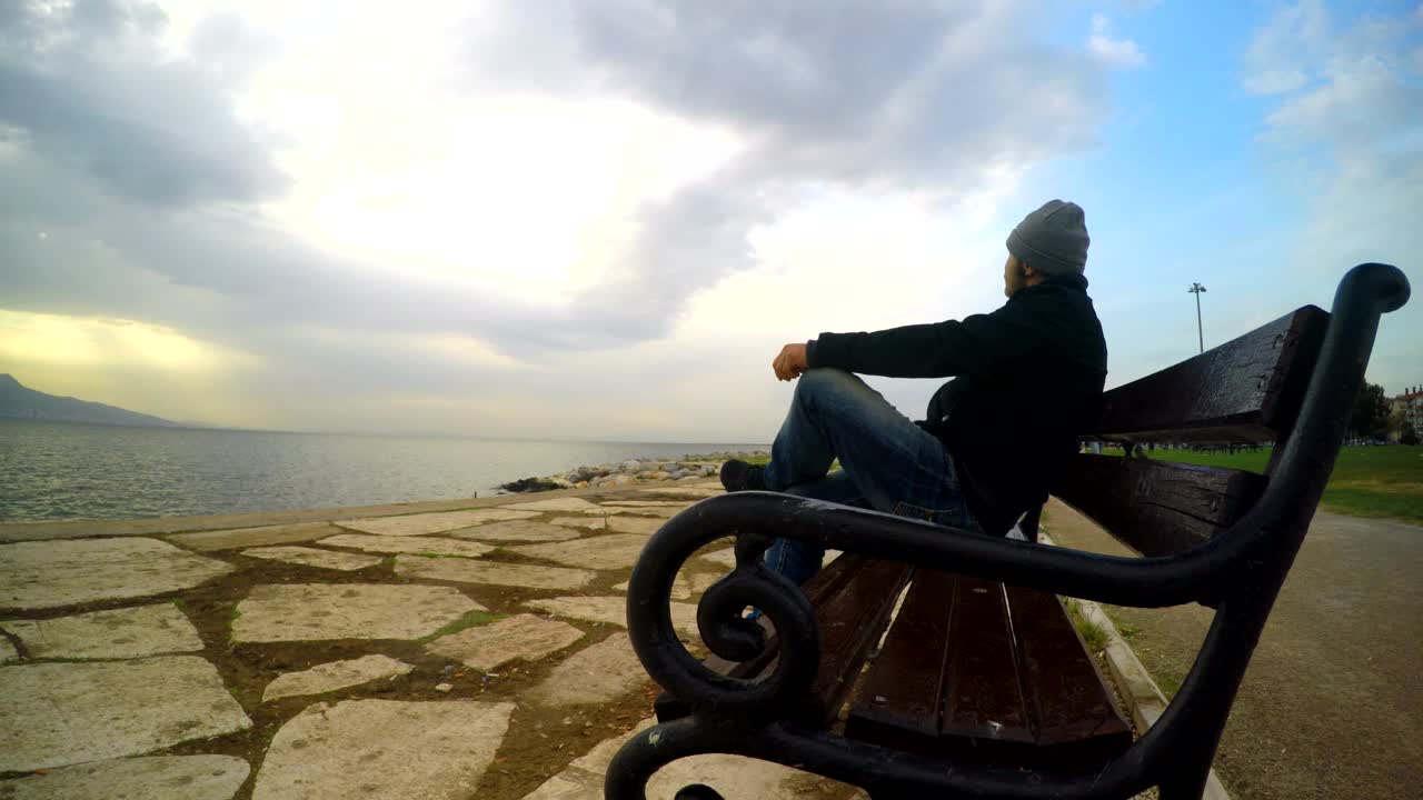 Stock Video Man Admiring The Sea On A Bench At The Pier Animated Wallpaper - Free Download