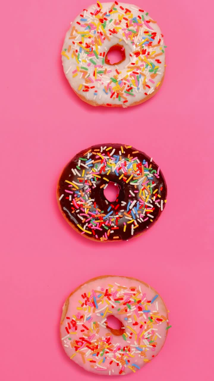 Free Video Stock taking three glazed donuts in a row on a pink Live Wallpaper - Free Download