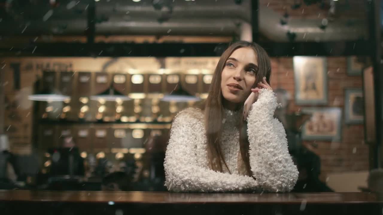 Free Video Stock Smiling Woman Watches Snowfall While On Mobile In Cafe Live Wallpaper - Free Download