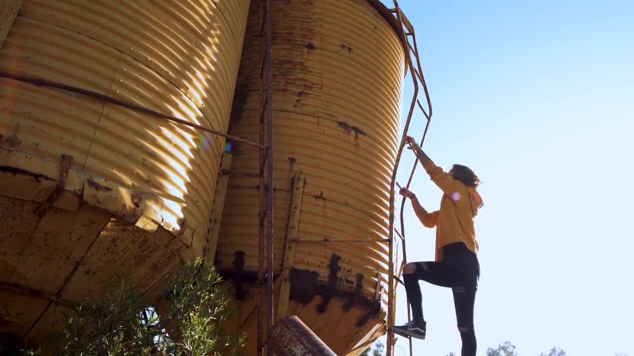 Stock Video Person Climbs Yellow Water Tower Live Wallpaper - Free Download