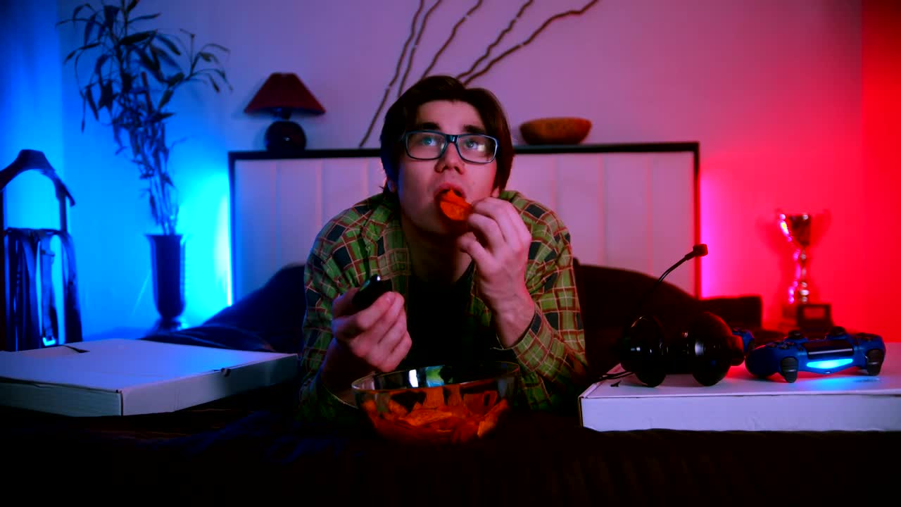 Free Stock Video Young Man Lying Down Watching Tv And Eating Snacks Live Wallpaper - Free Download