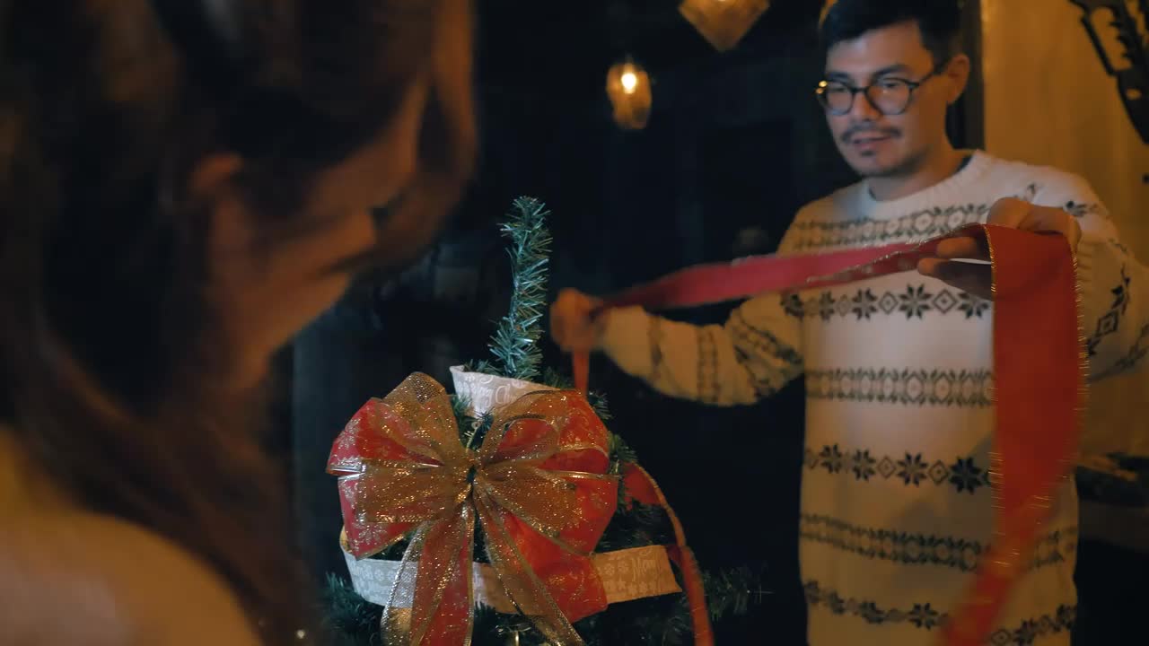 Stock Video Couple Of Man And Woman Decorating A Christmas Tree Live Wallpaper For PC - Free Download