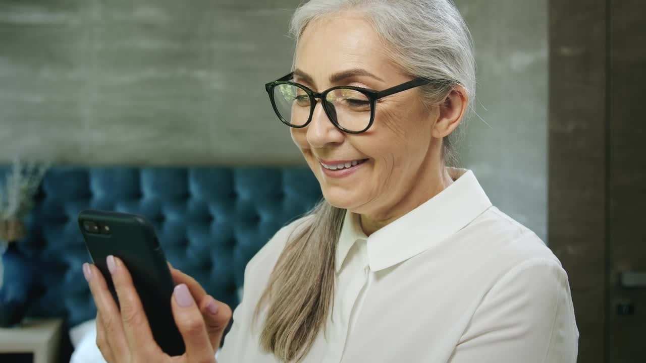 Stock Video Elderly Woman Smiles While Using Mobile App Live Wallpaper For PC - Free Download
