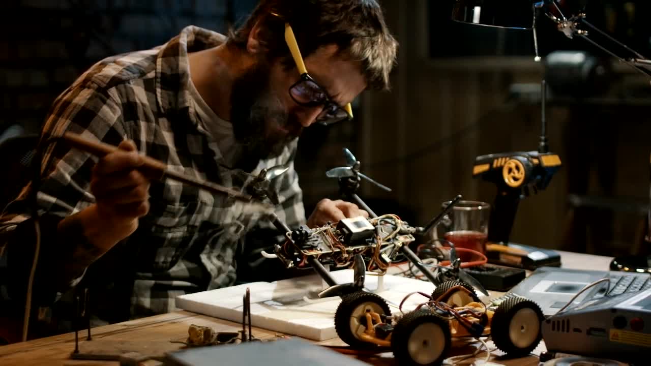 Stock Video Man With Glasses Soldering A Drone In The Garag Animated Wallpaper - Free Download