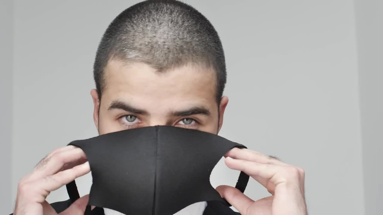 Stock Video Man Facing The Camera While Putting On A Mask Animated Wallpaper - Free Download