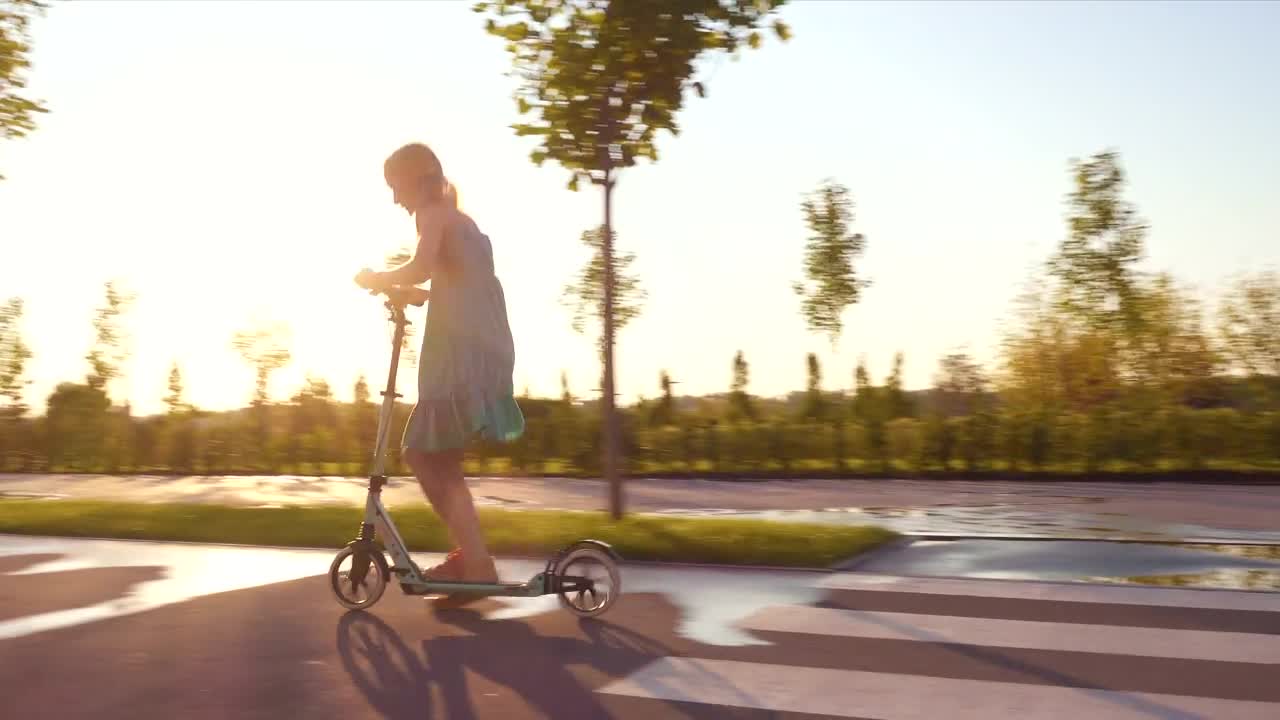 Stock Video Little Girl Riding A Scooter Through The Street Animated Wallpaper - Free Download